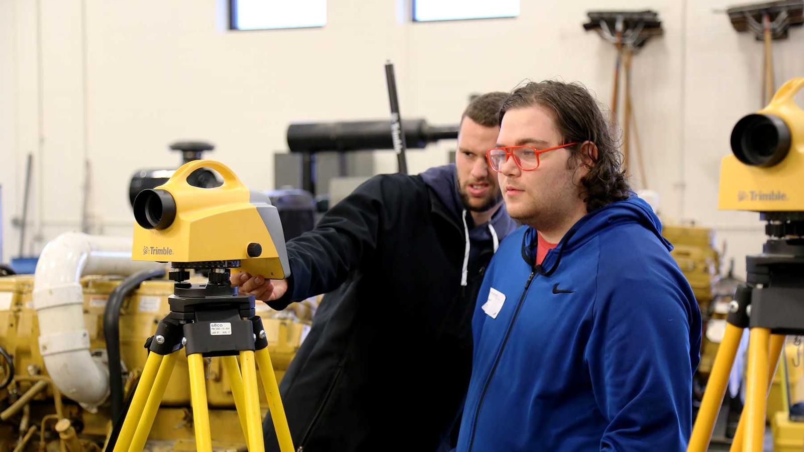 Two students looking at a digital level