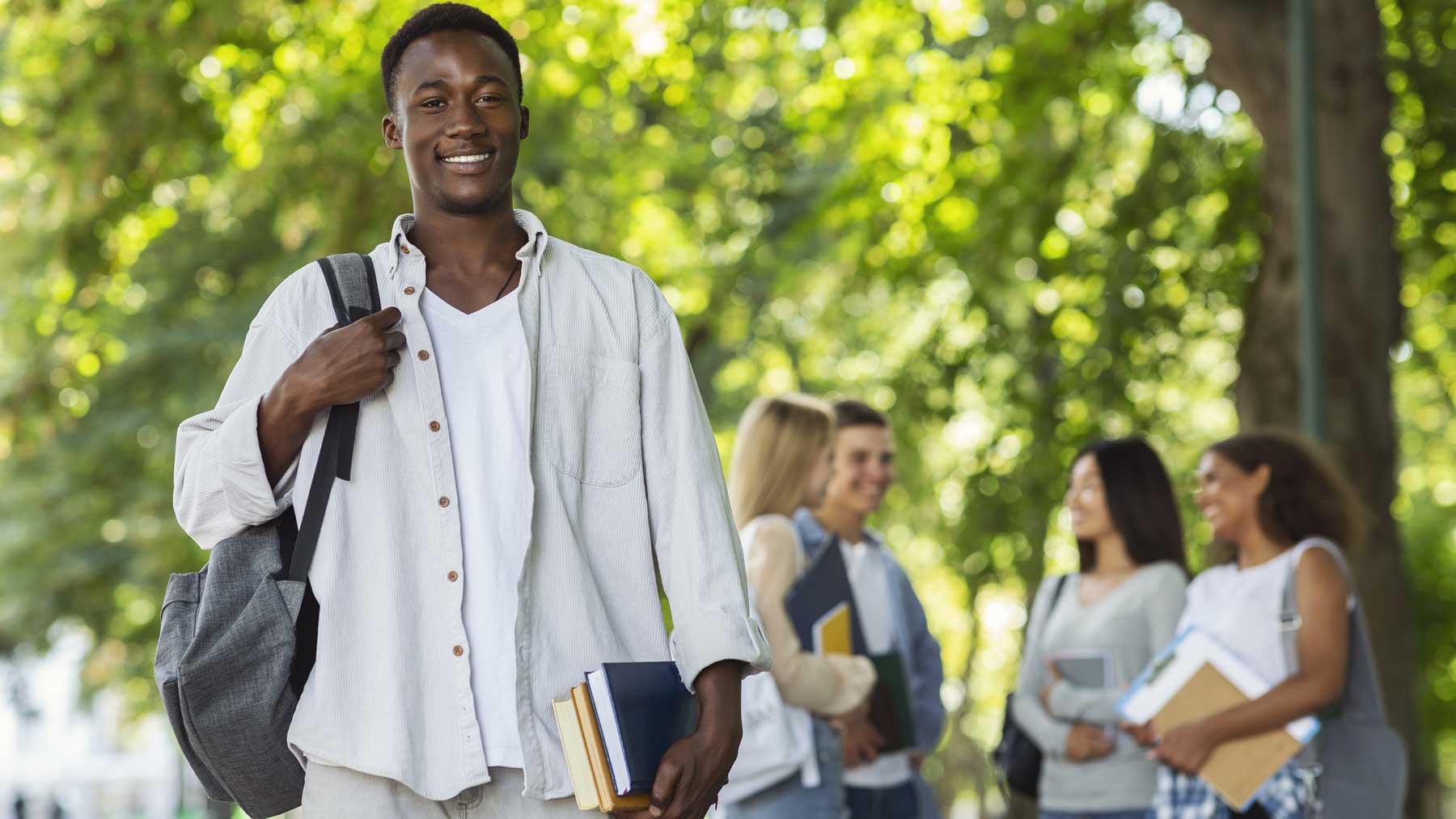 Student with teacher and open book at large table