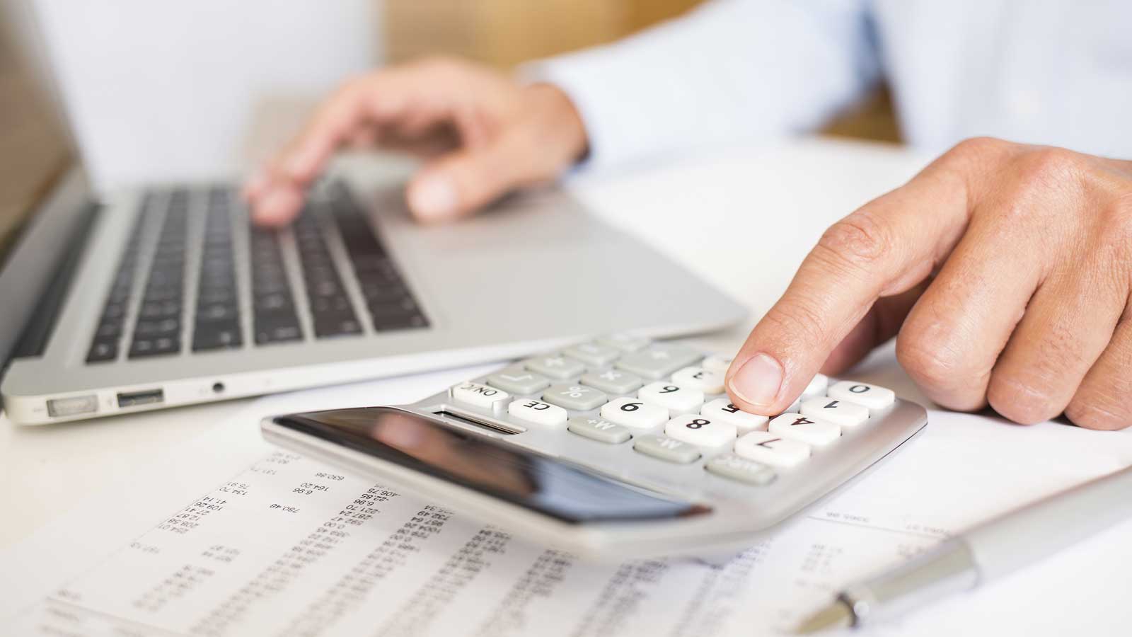 man using calcualtor pad and notepad screen