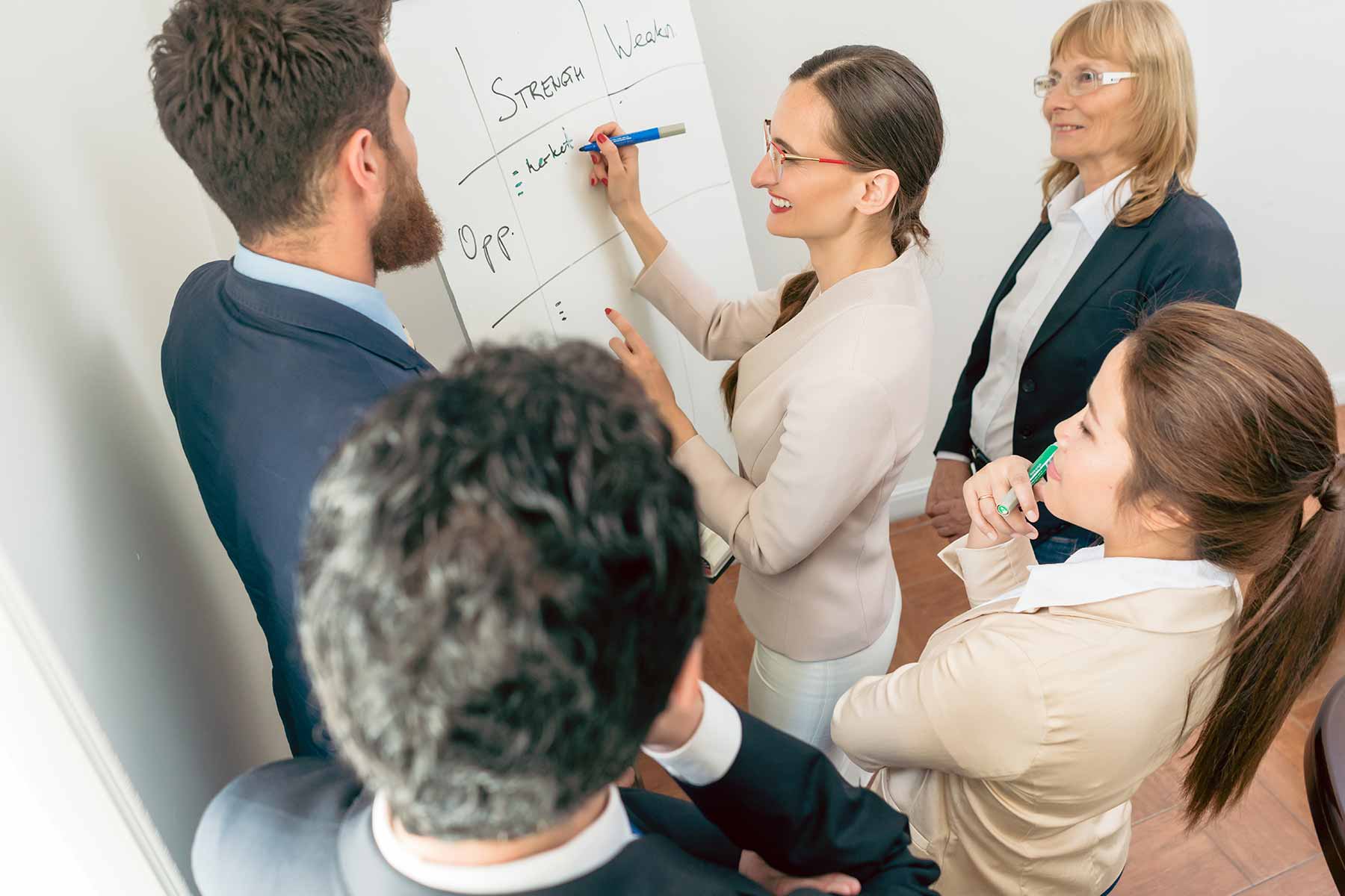 board members brainstorming on a large tablet