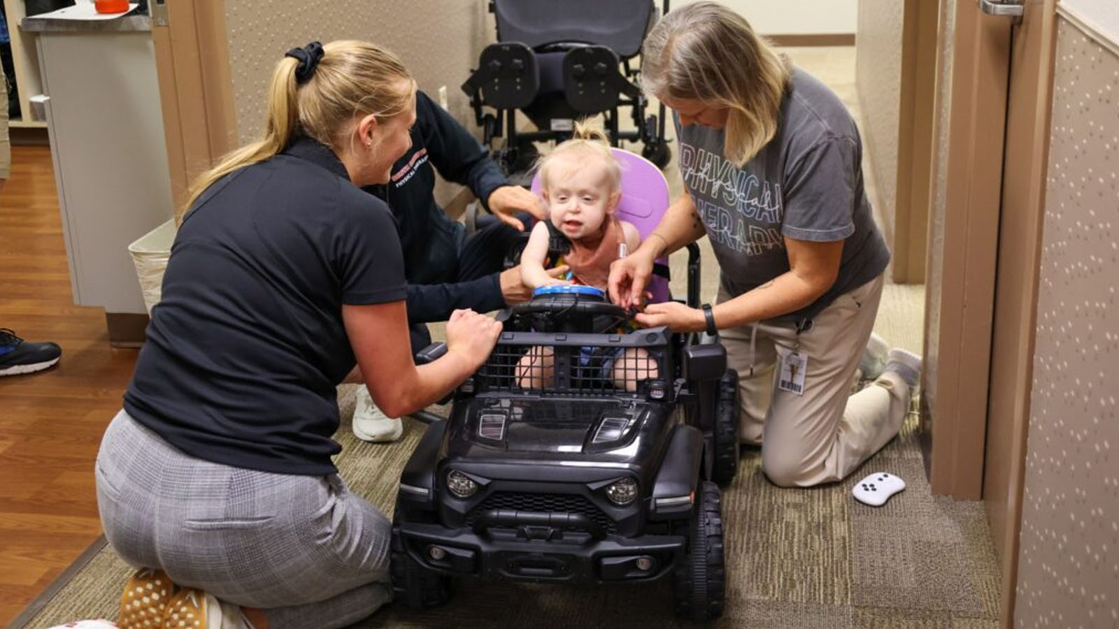 Physical Therapy students assist with ride-on car adjustments