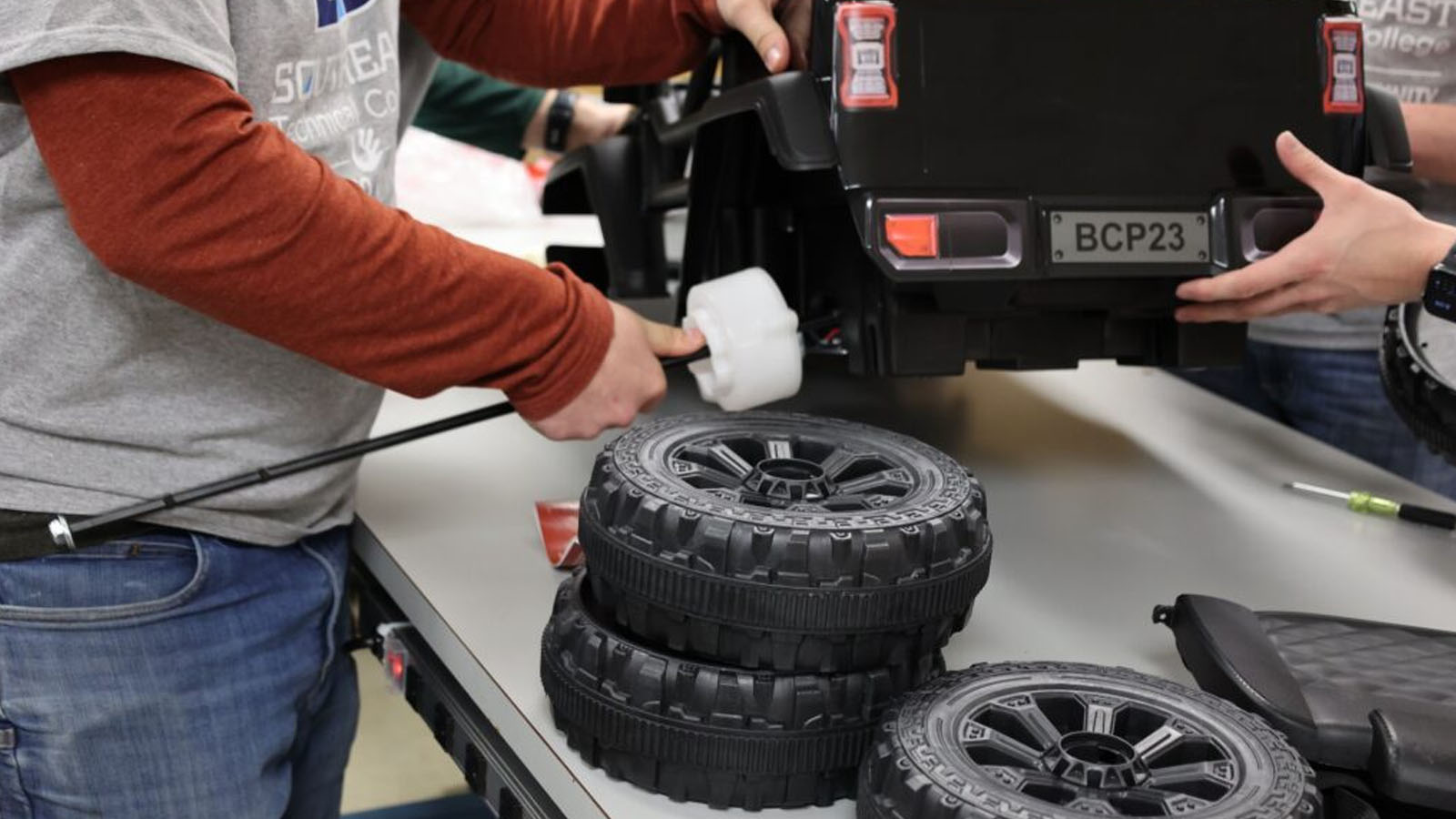 STC students attach wheels to ride-on car