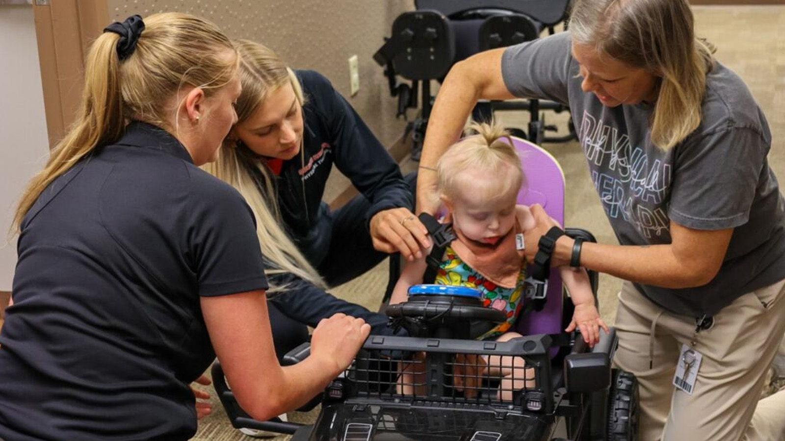 Physical therapists work help child into car