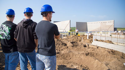 Students observing a large construction site with concrete
