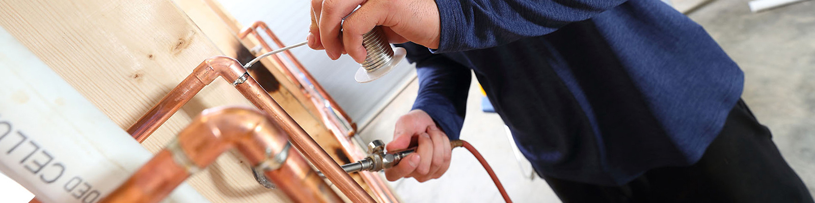 student sodering copper pipe