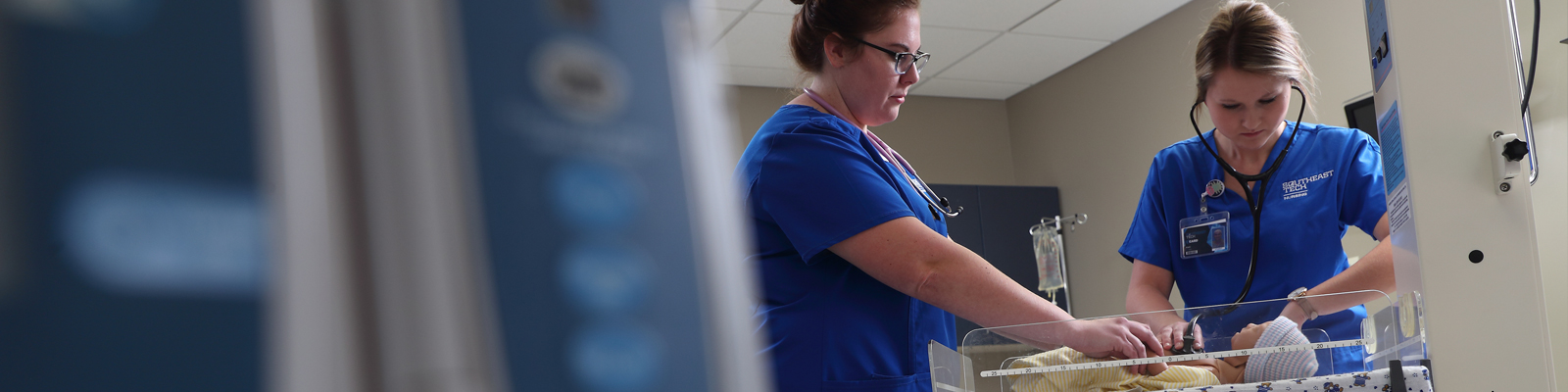 Southeast Tech taking blood pressure of a patient in a hospital bed