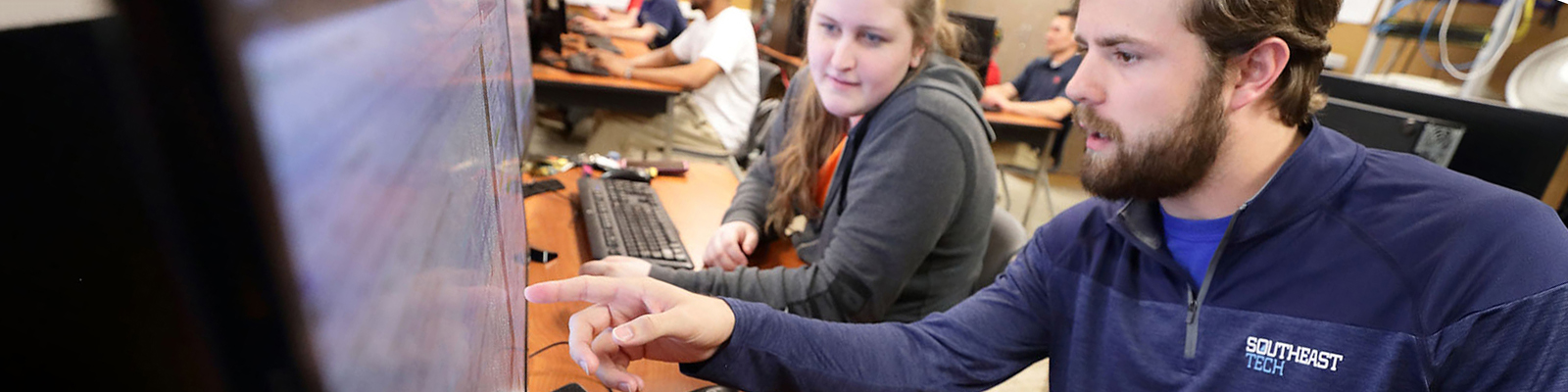 Two Southeast Tech students in a classroom, collaborating in front of a desktop computer