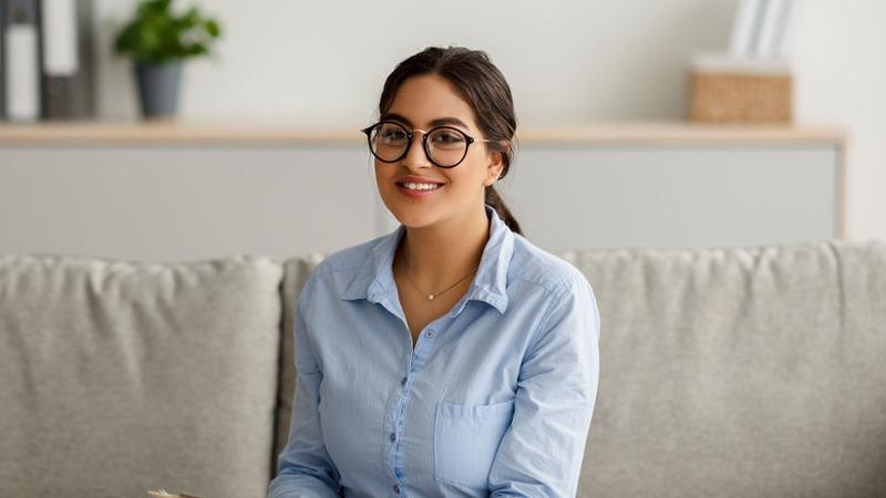 Young woman on couch with glasses