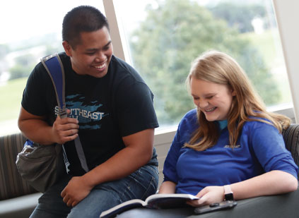 Two students looking at book