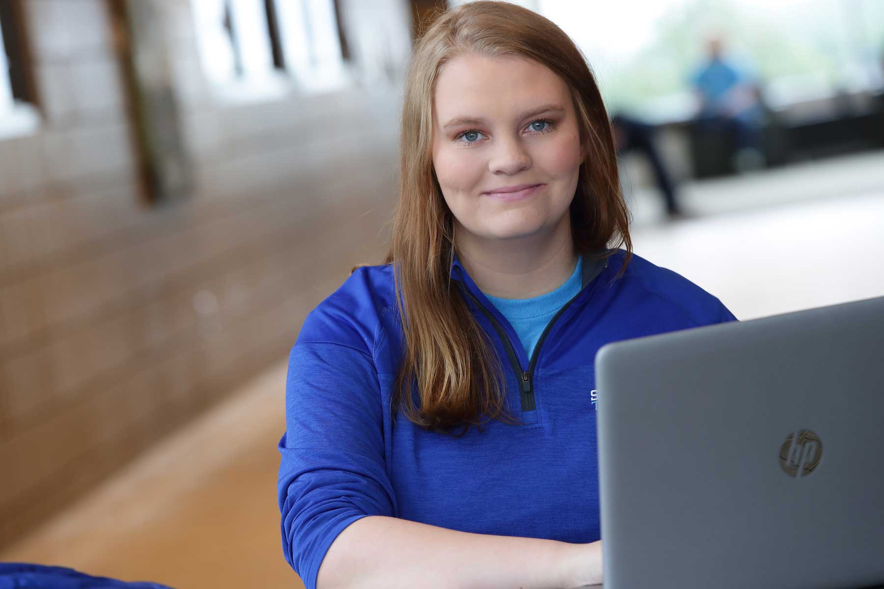 student in blue with laptop