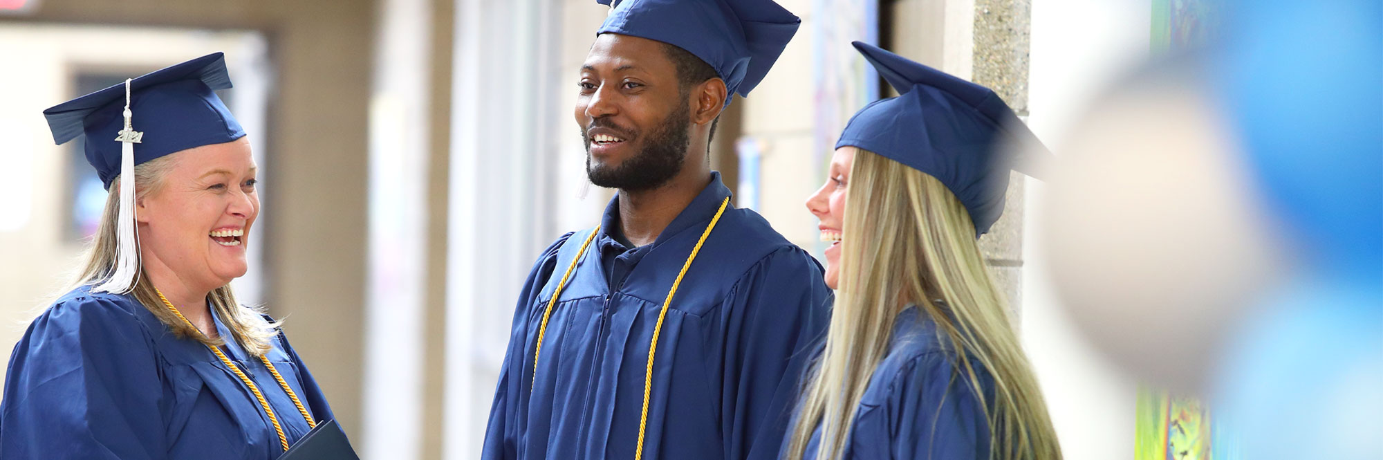 Southeast Tech graduates in cap and gown laughing