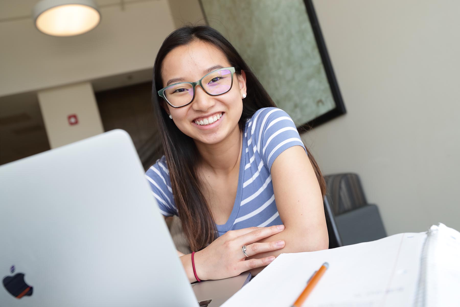 student with laptop smiling