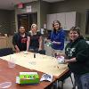 Early Childhood Student Organization students around craft table with tie die.