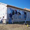 Students siding exterior of a home.
