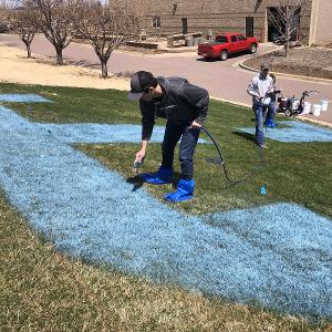 Jesse and Ryan painting the STC logo outside the Ed Wood Center at Southeast Tech.