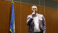 STC President Cory Clasemann with SD flag and microphone.